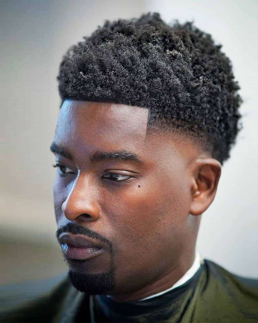 Black man with short neat afro and low skin fade