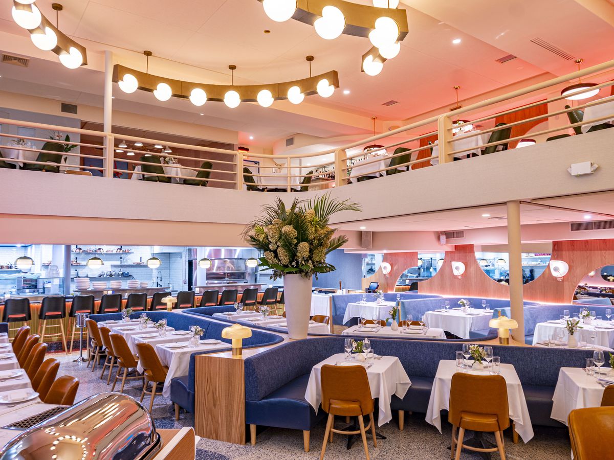 Experience the dining room of an art deco-inspired Midtown restaurant bathed in a captivating pink glow.