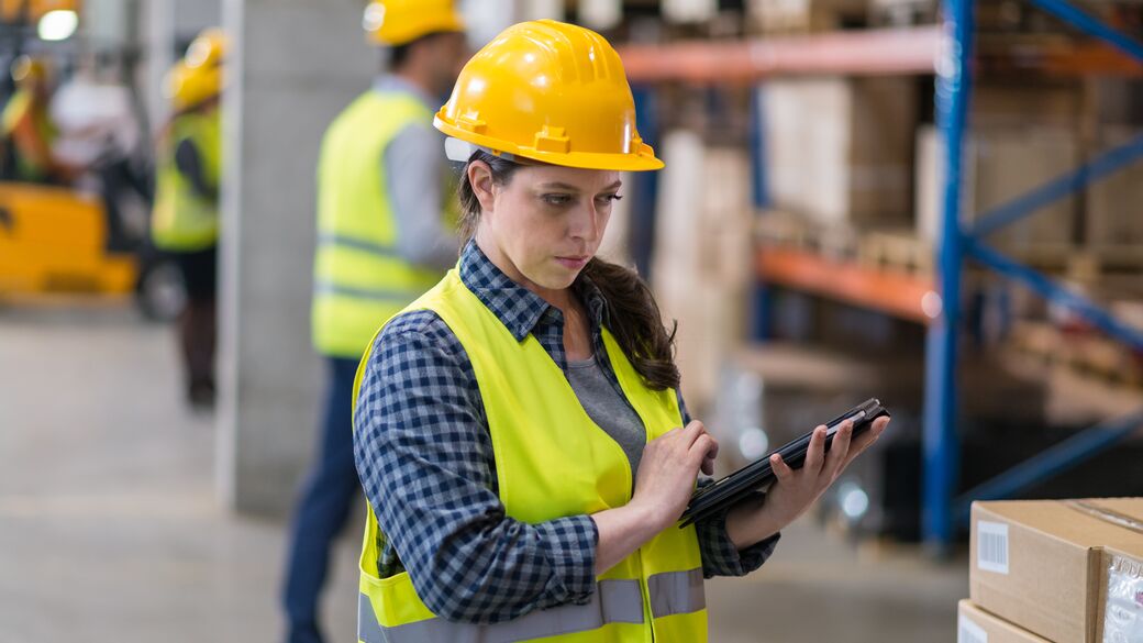woman in a warehouse holding a tablet